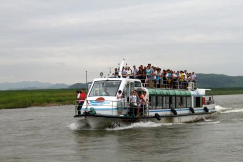 挤满游人的客船穿梭在朝鲜水域内，这是所谓的“内河游”。